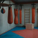 Interior view of a gym with boxing bags and equipment, designed for fitness enthusiasts.
