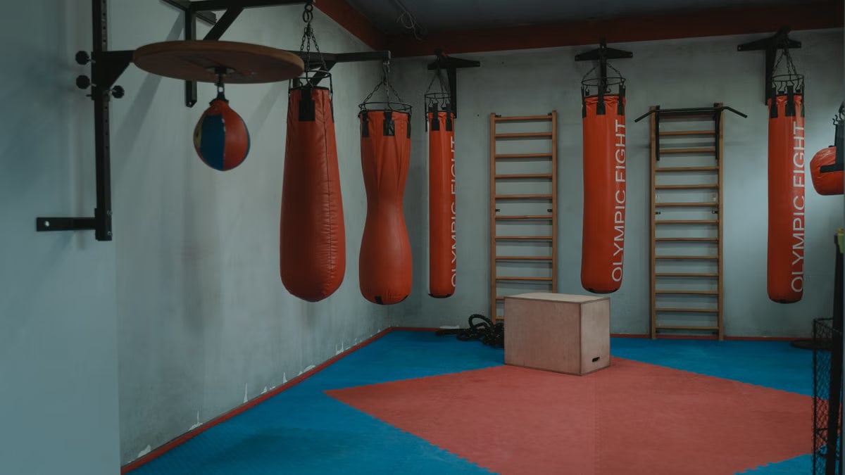 Interior view of a gym with boxing bags and equipment, designed for fitness enthusiasts.